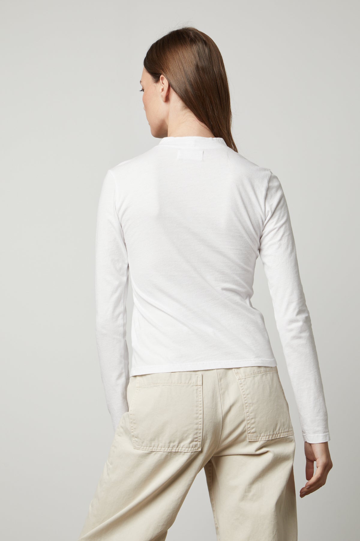   The back view of a woman wearing a Velvet by Graham & Spencer LINNY MOCK NECK TEE. 