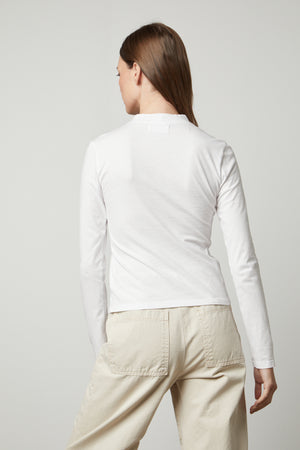 The back view of a woman wearing a Velvet by Graham & Spencer LINNY MOCK NECK TEE.