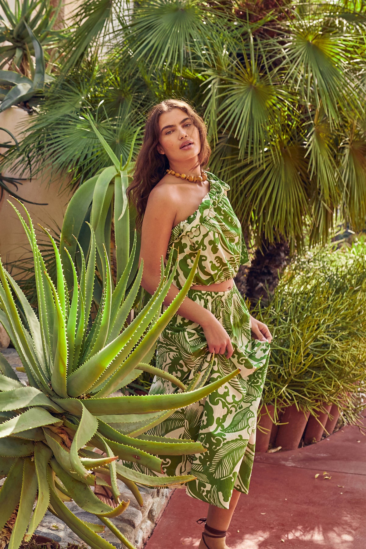a woman in a Velvet by Graham & Spencer Juliana Printed Maxi Skirt posing in front of plants.-26514159337665