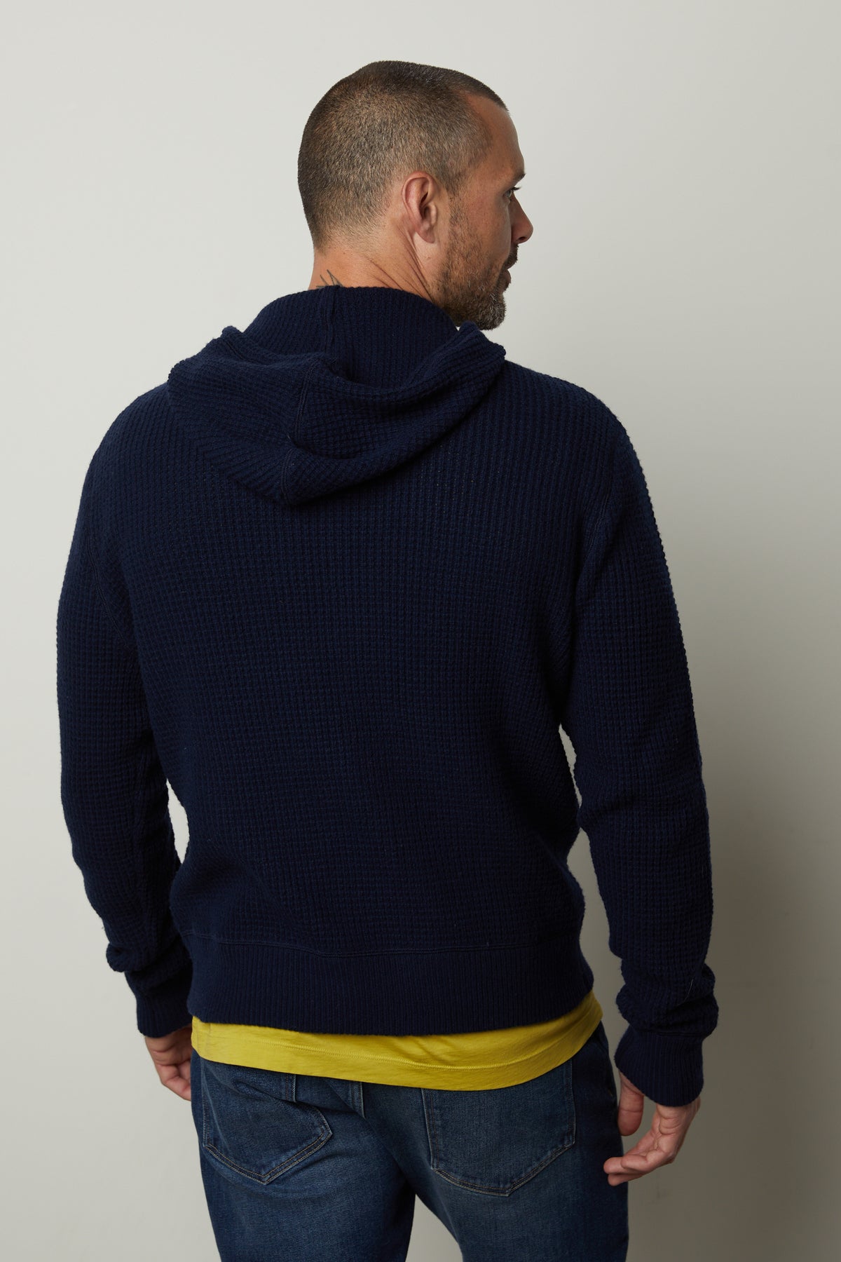 The back of a man wearing a Velvet by Graham & Spencer SHANE SWEATER HOODIE and jeans.-26846203510977