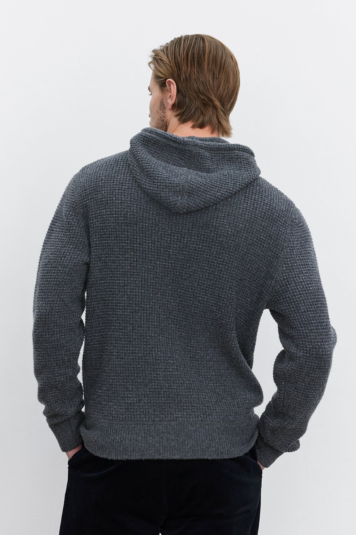   A person with light brown hair wearing a Velvet by Graham & Spencer SHANE SWEATER HOODIE stands facing away from the camera against a plain white background, evoking warmth and comfort. 