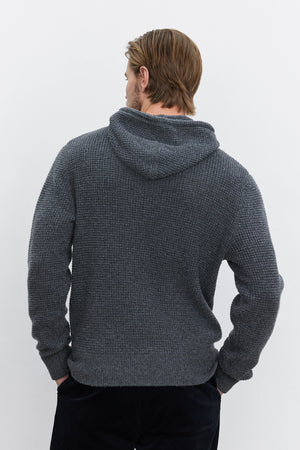 A person with light brown hair wearing a Velvet by Graham & Spencer SHANE SWEATER HOODIE stands facing away from the camera against a plain white background, evoking warmth and comfort.