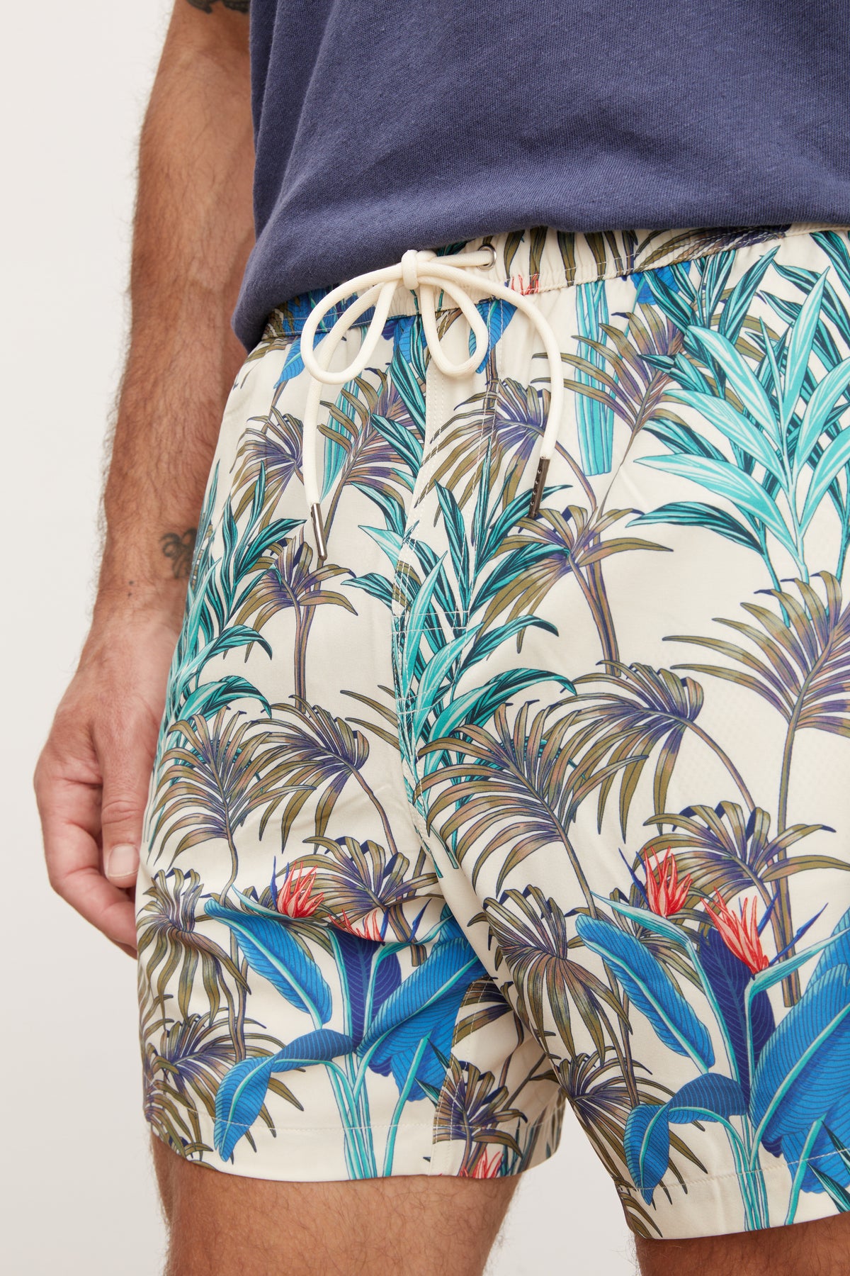   Close-up of a person wearing RICARDO SWIM SHORT by Velvet by Graham & Spencer, showcasing the pattern detail and fabric texture. 