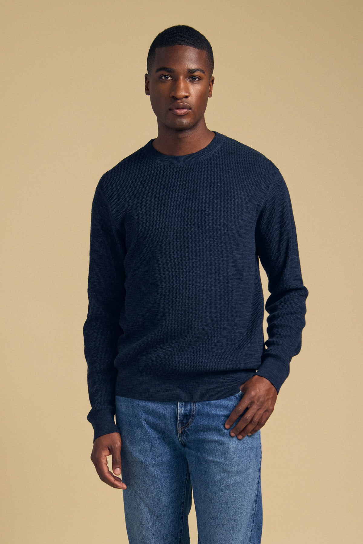 A man wearing a navy blue cotton linen blend CONOR SWEATER by Velvet by Graham & Spencer and blue jeans.-46288239558849