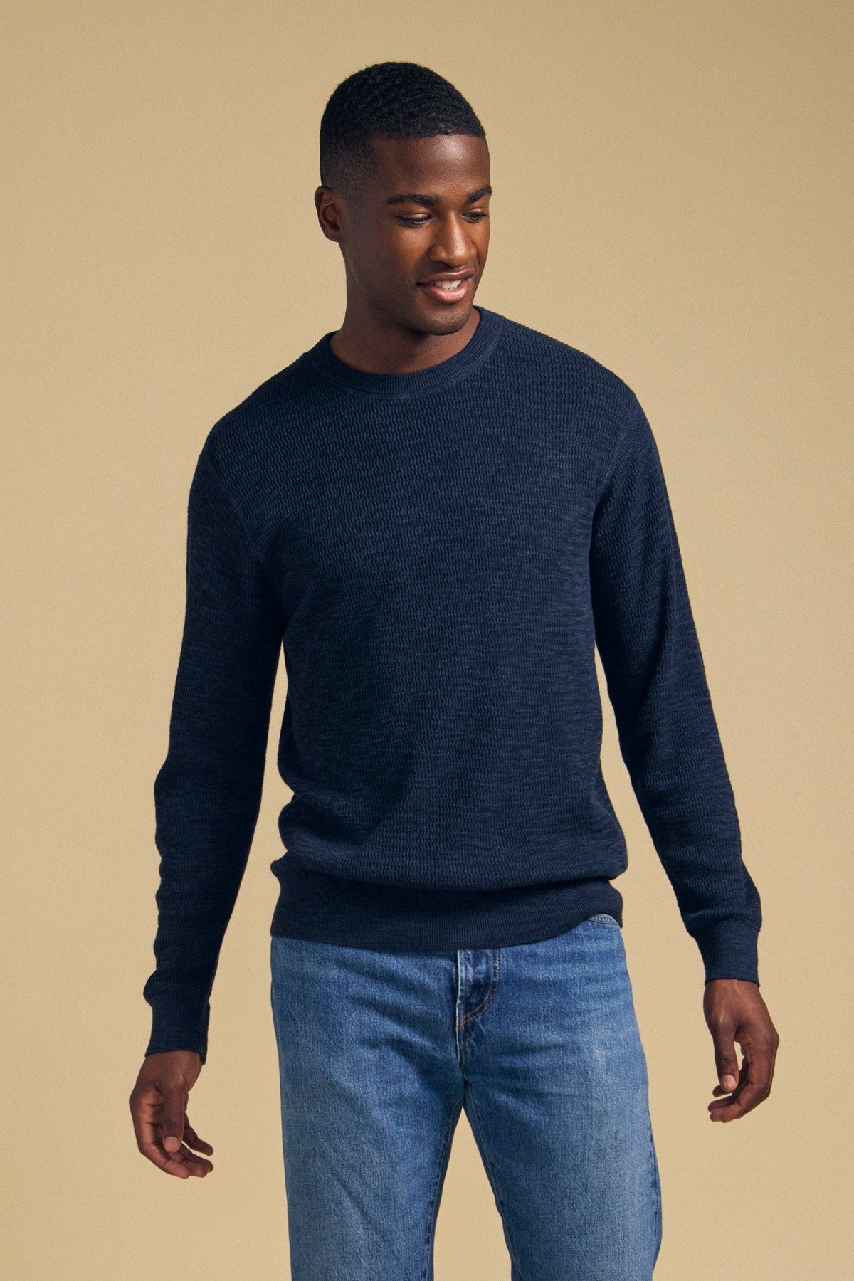 A man wearing a navy blue cotton linen blend CONOR SWEATER by Velvet by Graham & Spencer and blue jeans.-46288239624385