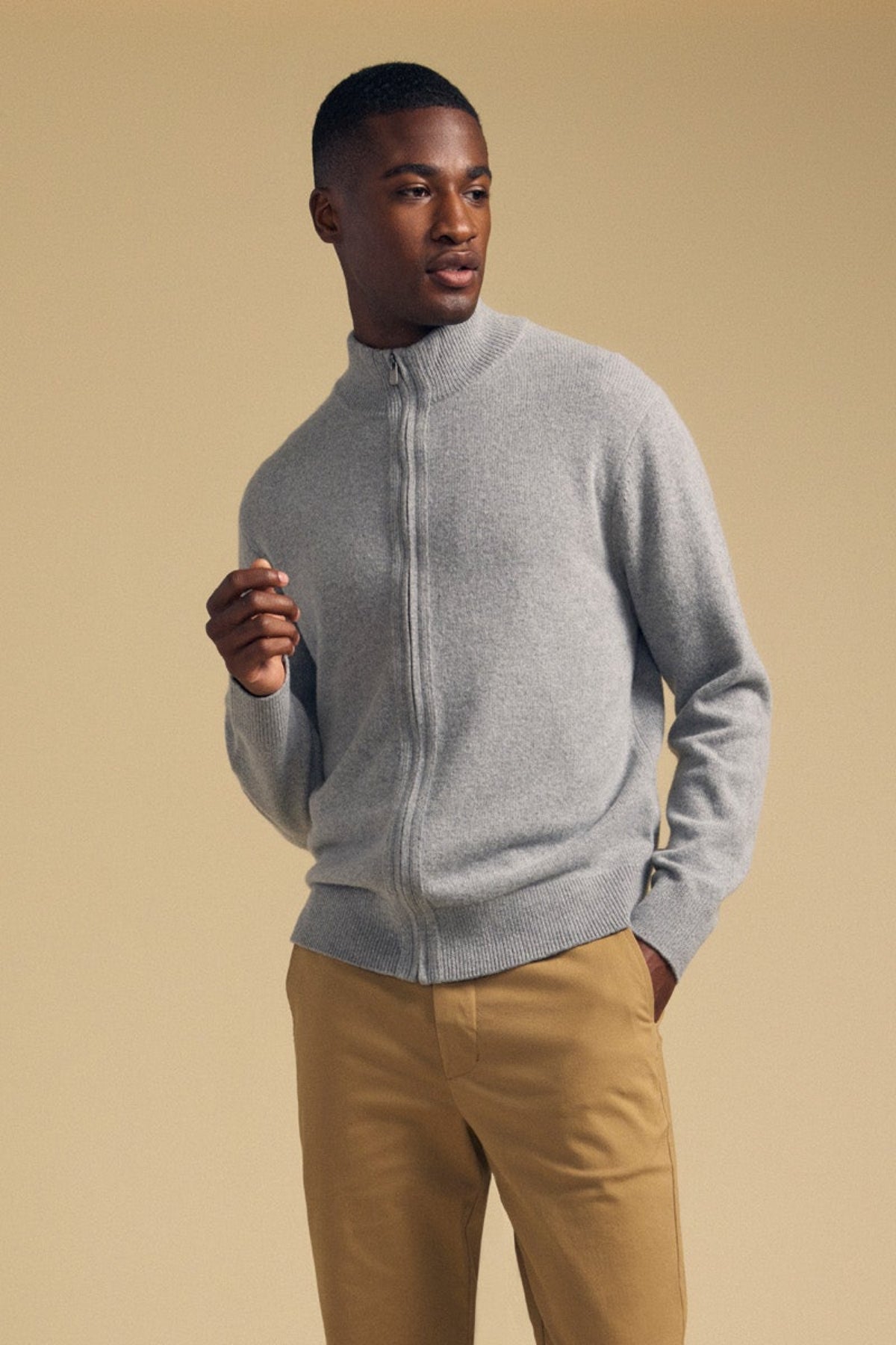 A person wearing a grey DALLEN FULL-ZIP SWEATER and tan trousers.