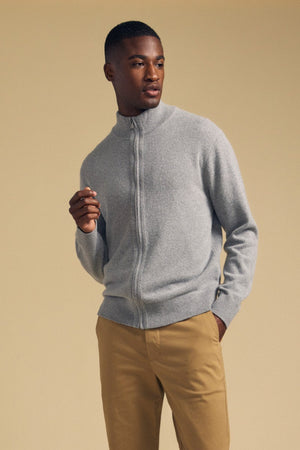 A person wearing a grey DALLEN FULL-ZIP SWEATER and tan trousers.