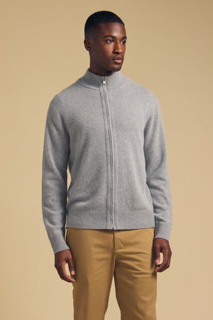 A man wearing a grey Velvet by Graham & Spencer DALLEN FULL-ZIP SWEATER and tan trousers.
