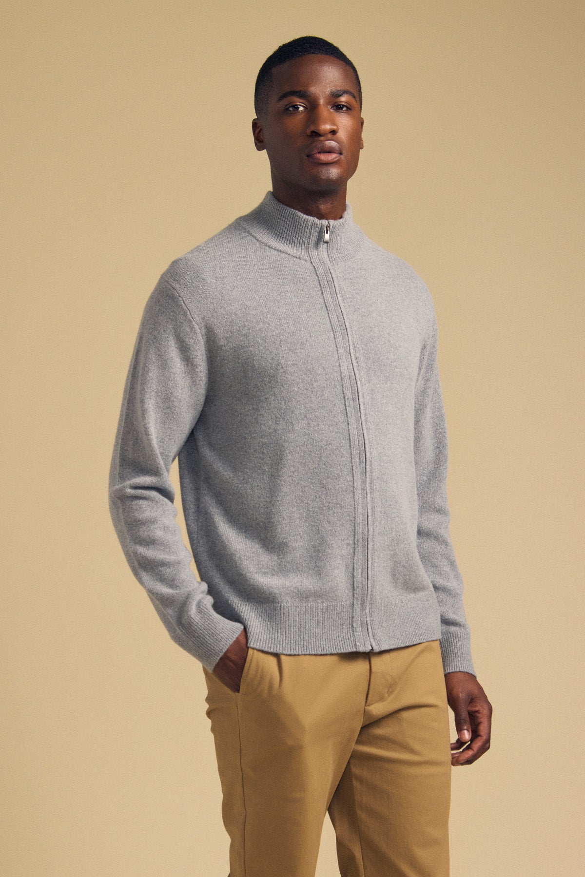 A man wears a gray, long-sleeved DALLEN FULL-ZIP SWEATER and tan trousers.-46288247292097
