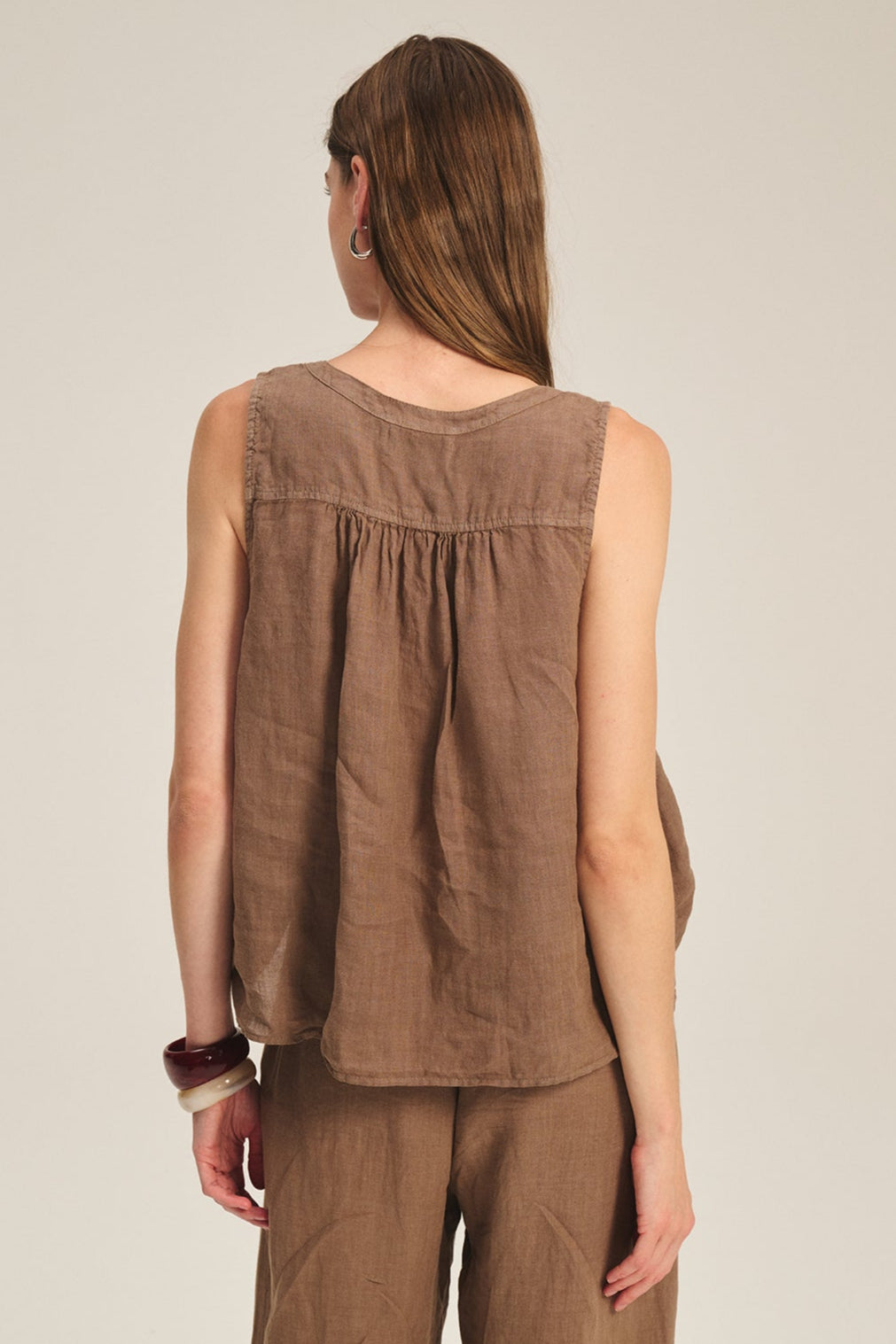 A person with long brown hair, shown from the back against a neutral background, wears the TACY LINEN TANK TOP by Velvet by Graham & Spencer in a relaxed fit with matching pants.-39601053597889