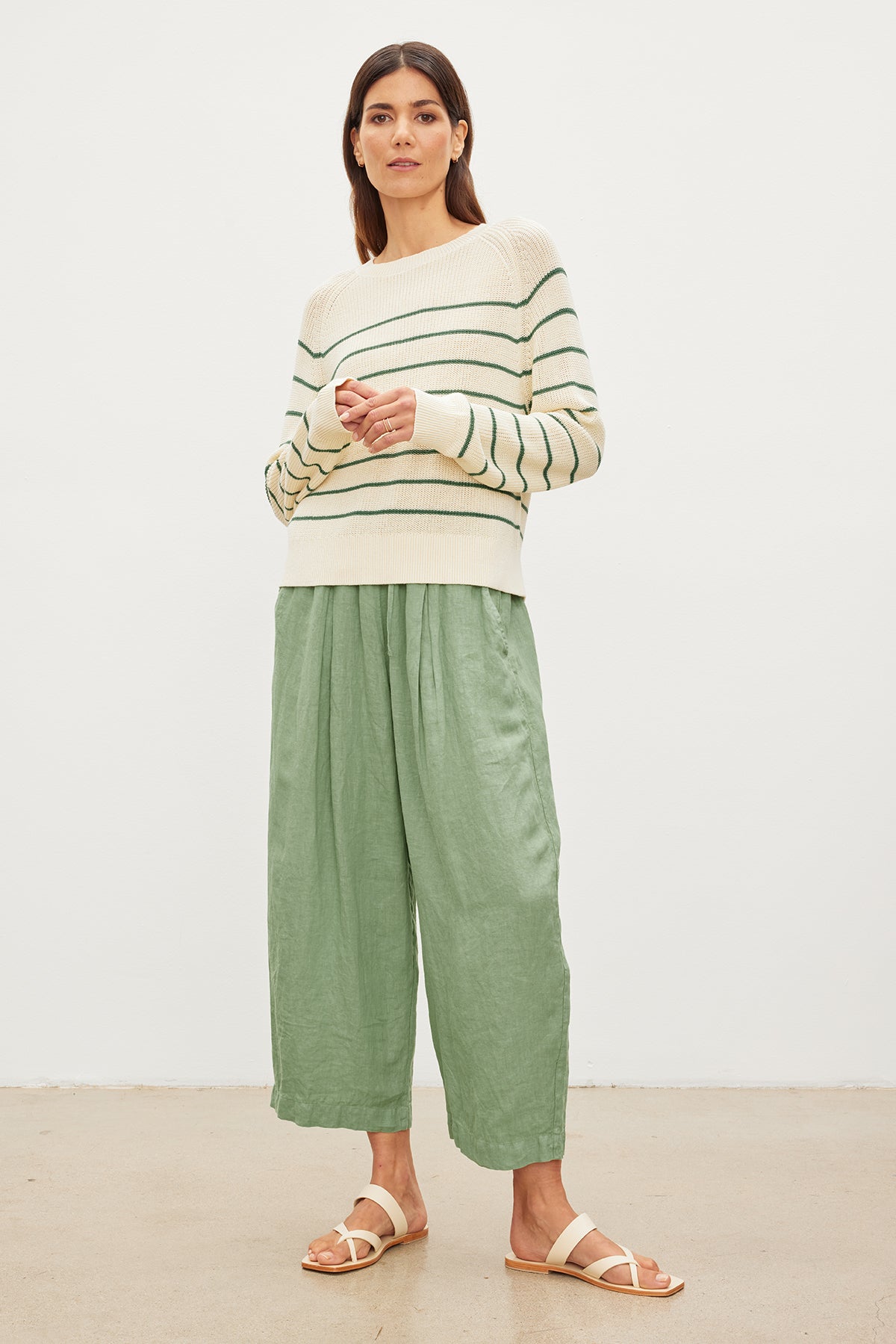   The model is wearing a CHAYSE STRIPED CREW NECK SWEATER by Velvet by Graham & Spencer in a relaxed silhouette and textured cotton culottes. 