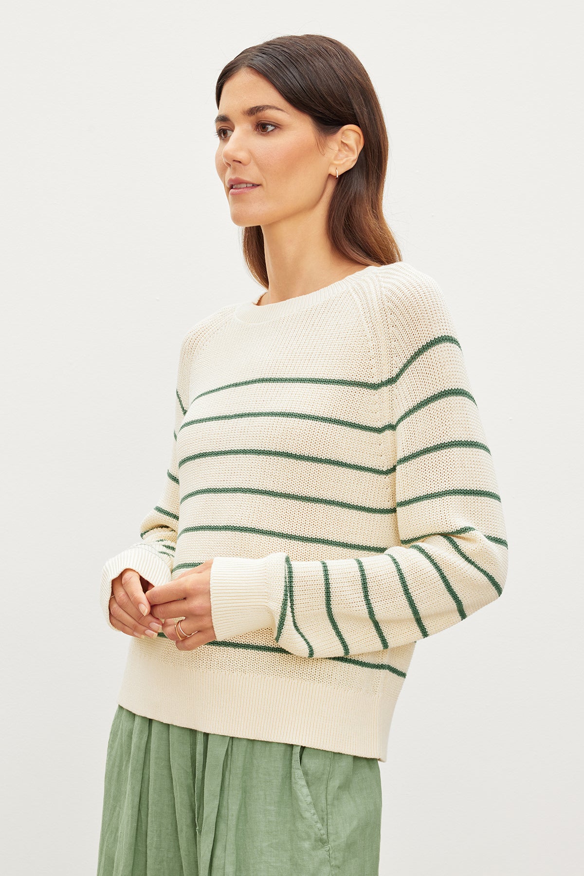   The model is wearing a Velvet by Graham & Spencer CHAYSE STRIPED CREW NECK SWEATER. 