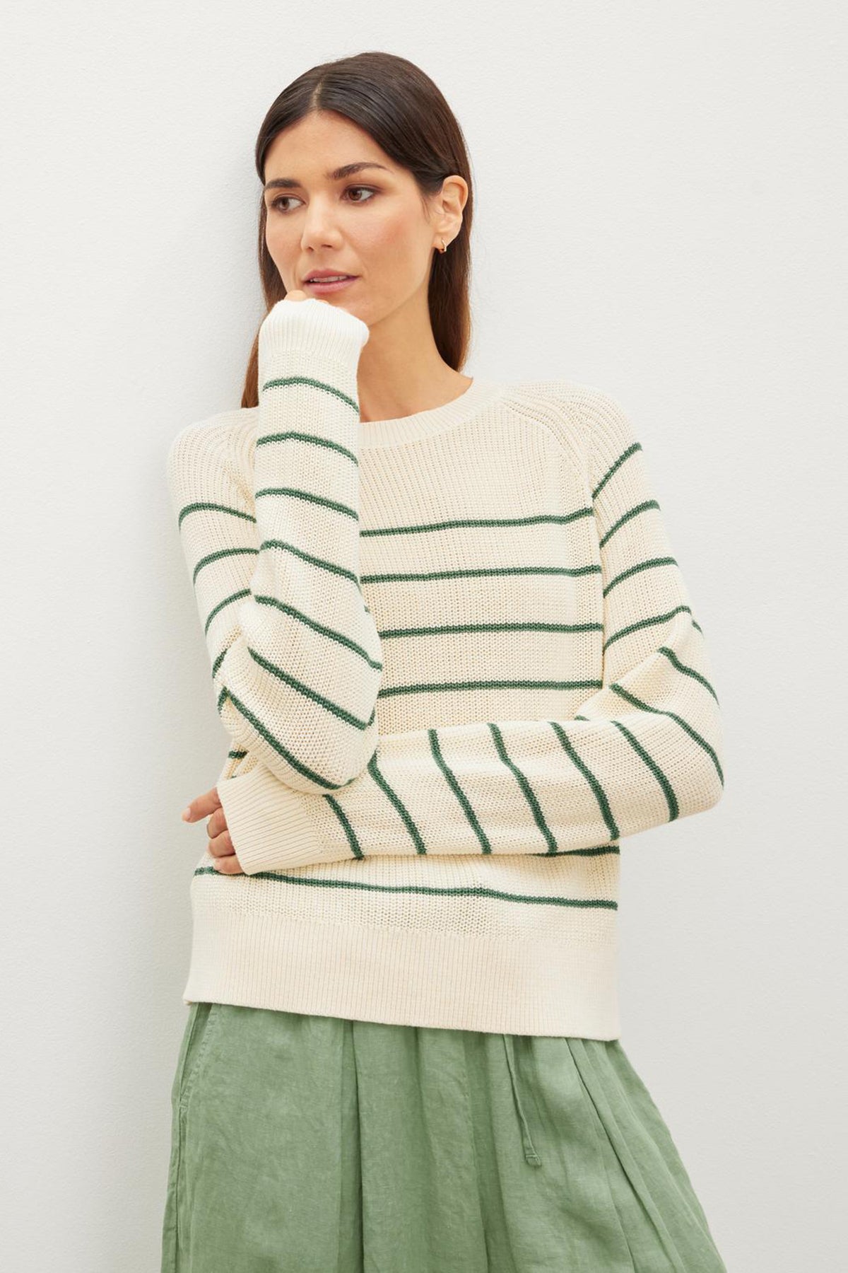   The model is wearing a Velvet by Graham & Spencer CHAYSE STRIPED CREW NECK SWEATER as part of her casual wear ensemble. 