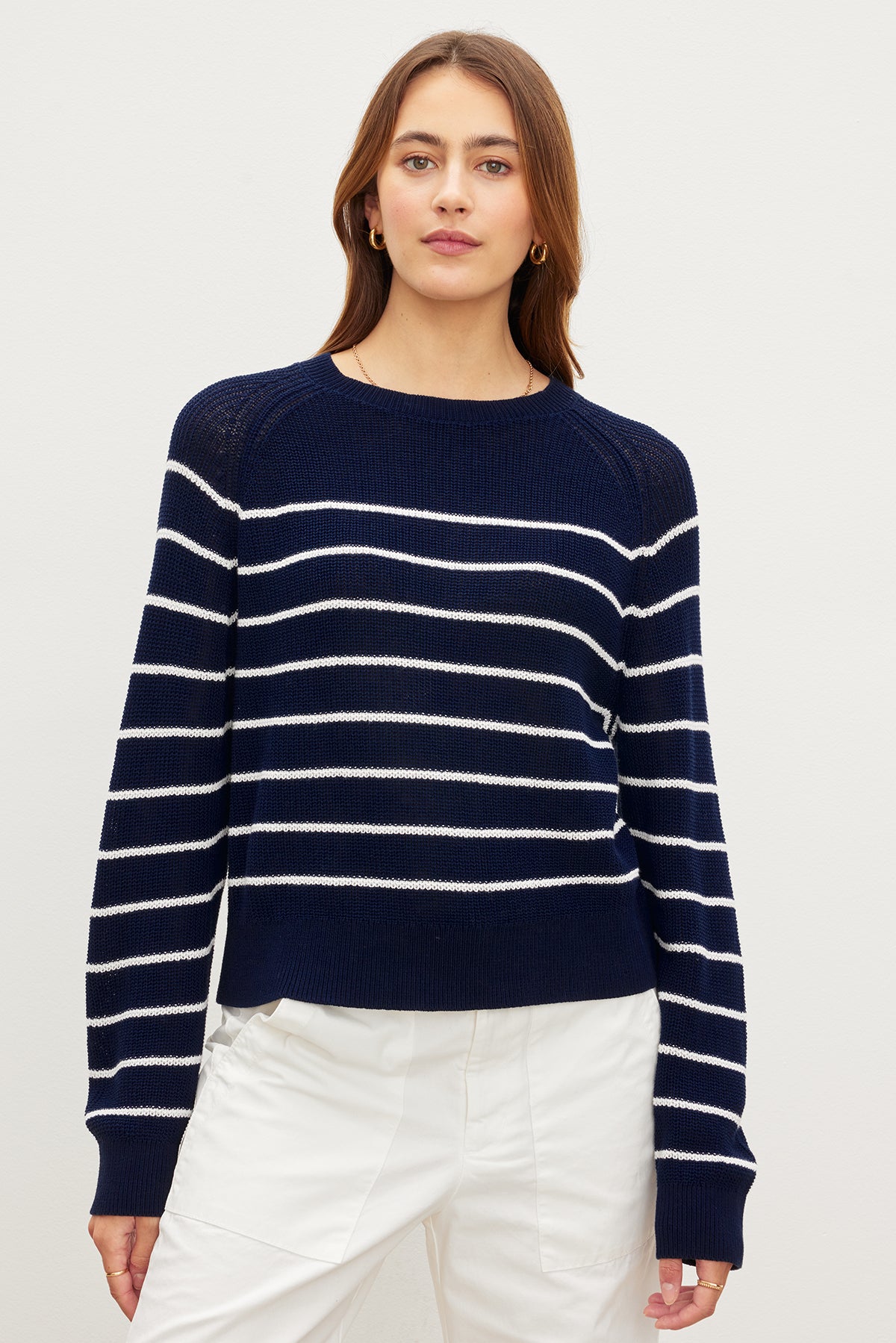 A woman wearing a Velvet by Graham & Spencer CHAYSE STRIPED CREW NECK SWEATER, a relaxed silhouette, navy and white striped sweater made of textured cotton.-35955537215681