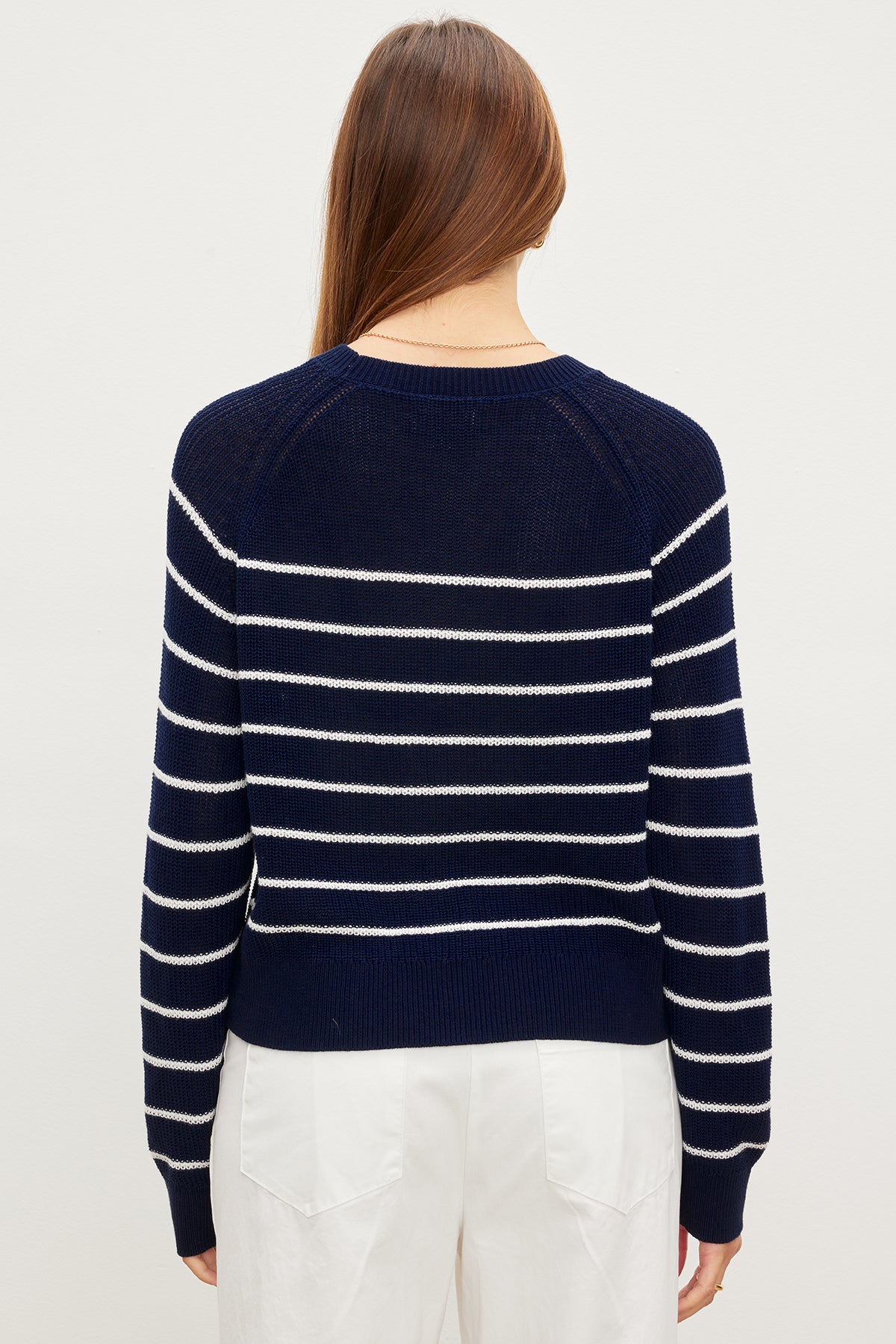   The back view of a woman wearing a Velvet by Graham & Spencer CHAYSE STRIPED CREW NECK SWEATER in textured cotton. 