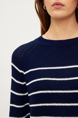The model is wearing a Velvet by Graham & Spencer CHAYSE STRIPED CREW NECK SWEATER with a relaxed silhouette.
