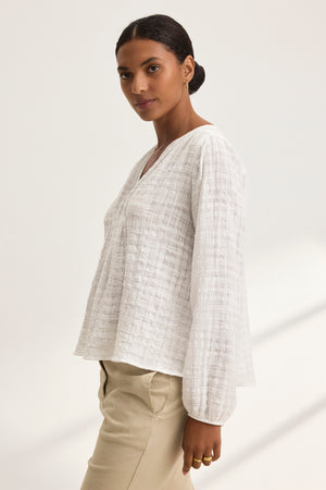 Someone is wearing the KORA Textured Cotton Gauze Top by Velvet by Graham & Spencer, paired with beige pants, standing against a plain background.