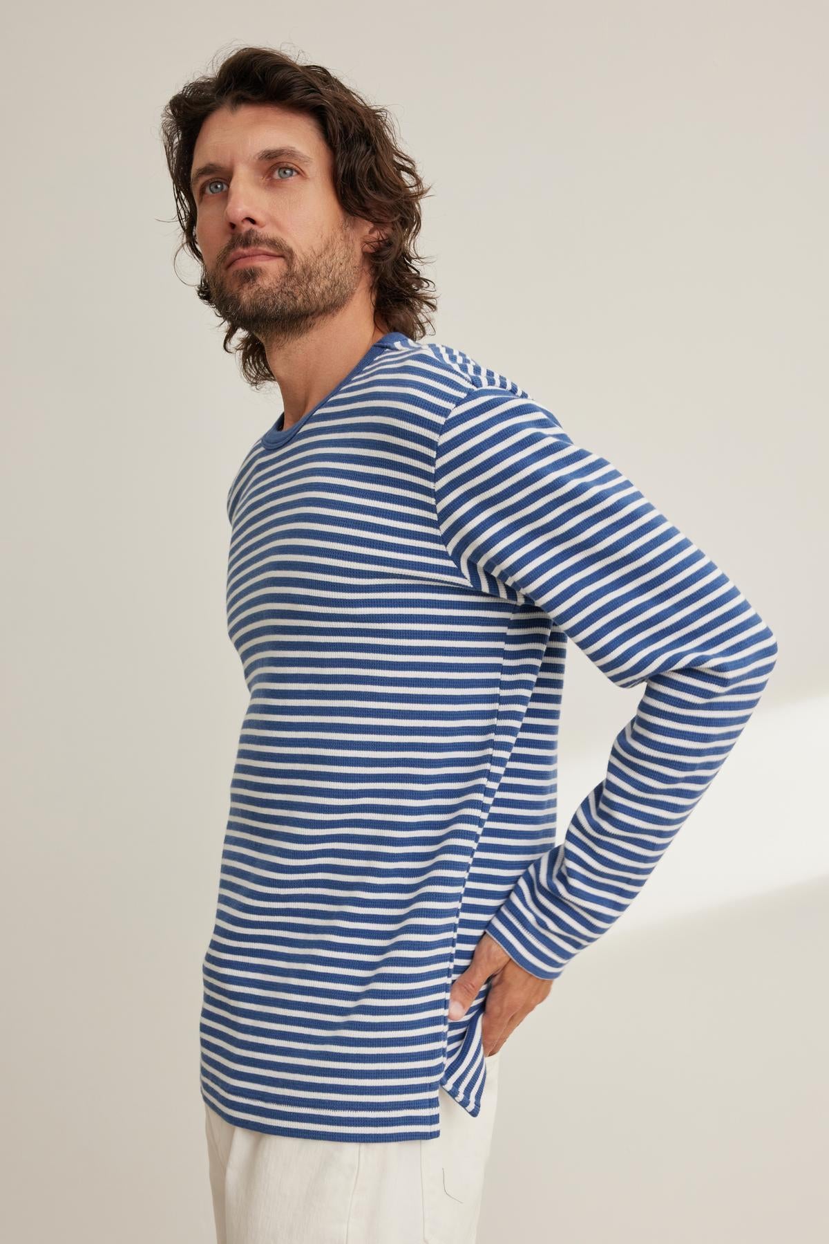 A man in the HARLAN THERMAL STRIPED CREW by Velvet by Graham & Spencer and white pants looks to the side.-38643303841985