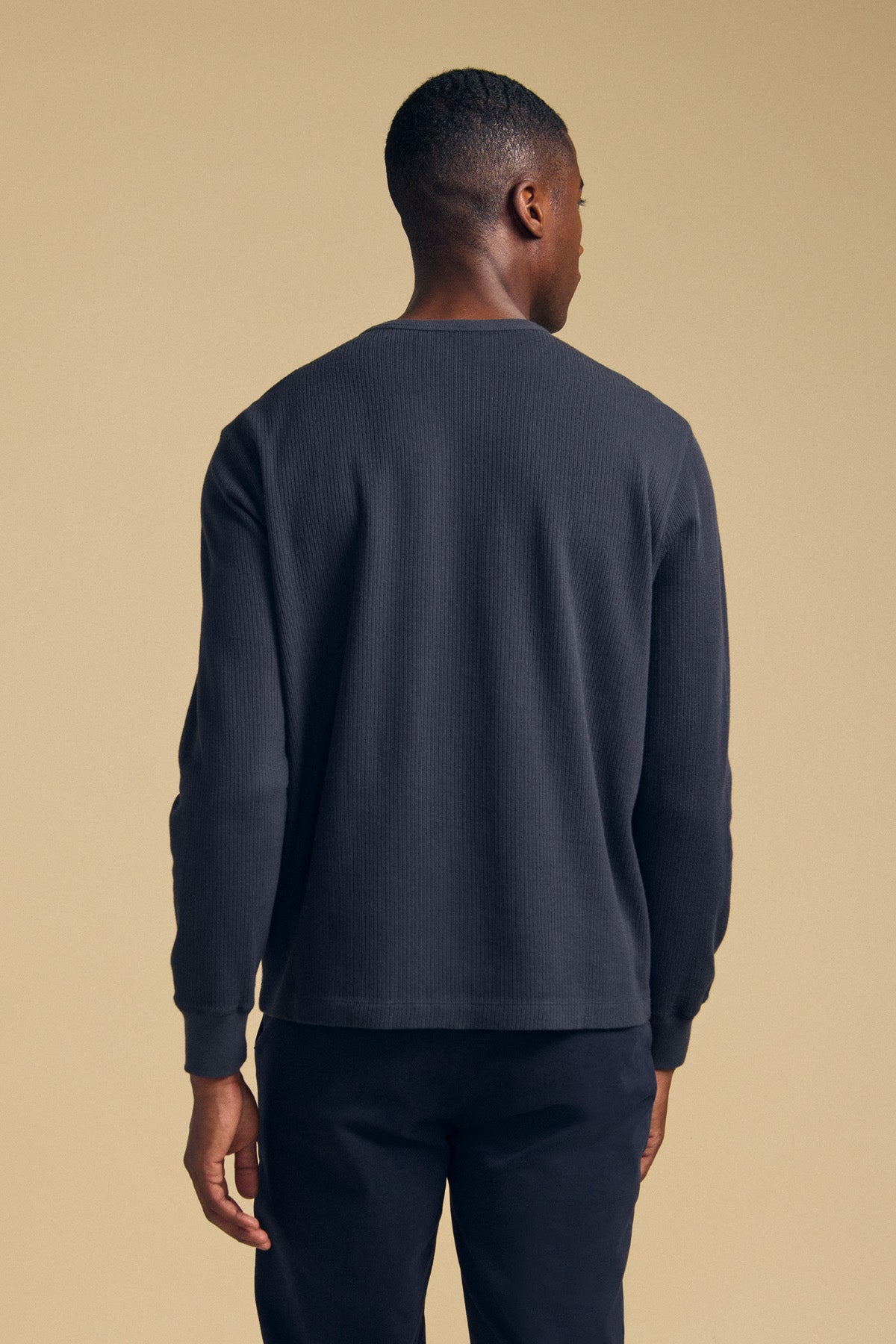 A man seen from the back wearing a dark gray long-sleeve DARIEL THERMAL PULLOVER.