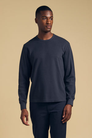 A man wearing a charcoal gray, long-sleeved DARIEL THERMAL PULLOVER.