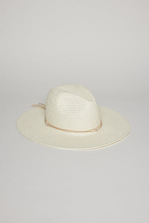 A white, wide-brimmed TRAVELER CONTINENTAL HAT by Velvet by Graham & Spencer with a beige band around the base of the crown, placed on a light grey surface.