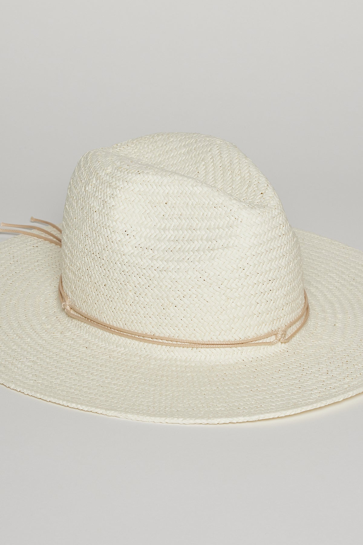 A white straw hat with a wide brim and a beige band around the base of the crown, perfect as a stylish travel hat, displayed on a plain white background. The TRAVELER CONTINENTAL HAT by Velvet by Graham & Spencer.-36290936045761