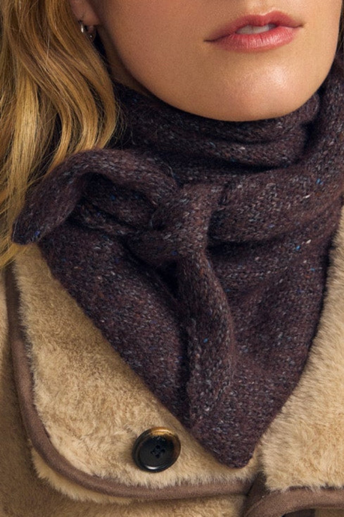 A person wearing the KARLA SCARF by Velvet by Graham & Spencer, tied in a knot and layered over a tan shearling coat with large buttons. Only the lower face and upper chest are visible, highlighting this cozy accessory.-42063770878145