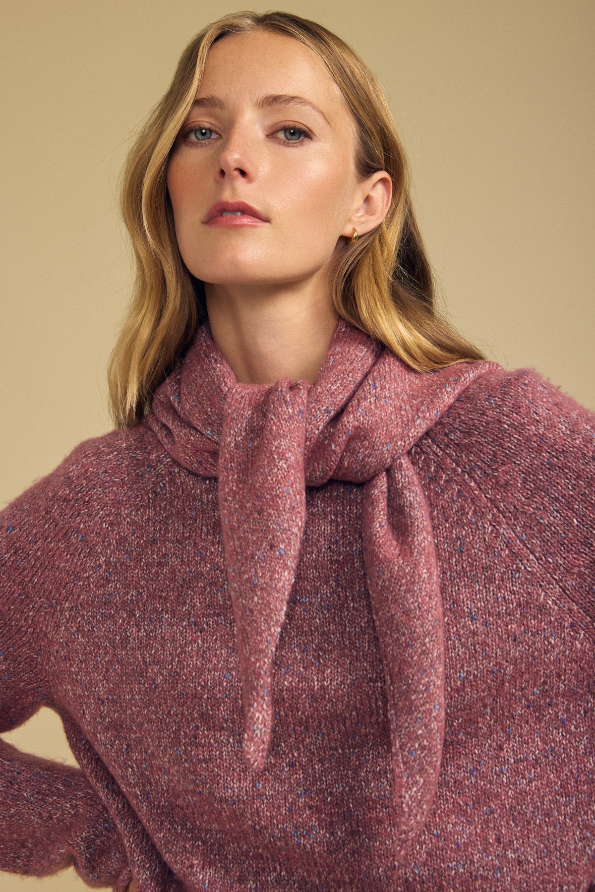 A woman with long blonde hair wears a textured pink wool blend sweater from Velvet by Graham & Spencer, styled with the matching KARLA SCARF draped over her shoulders and tied at the front, set against a neutral beige background.