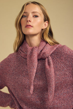 A woman with long blonde hair wears a textured pink wool blend sweater from Velvet by Graham & Spencer, styled with the matching KARLA SCARF draped over her shoulders and tied at the front, set against a neutral beige background.