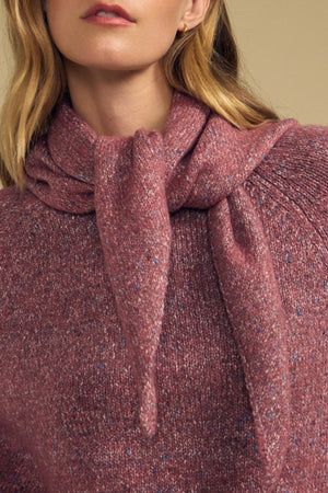 A woman wears the KARLA SCARF by Velvet by Graham & Spencer, a wool blend accessory styled as a layering piece and tied around her neck over a textured mauve knit sweater. Only the lower half of her face and upper torso are visible.