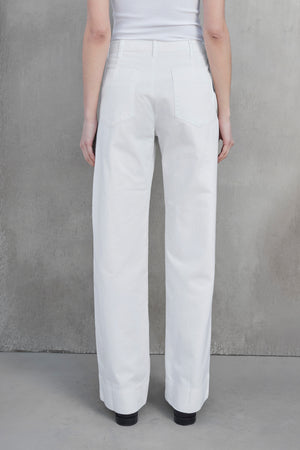 Rear view of a person wearing the VENTURA PANT — white high-waisted, wide-leg pants made from cotton twill by Velvet by Jenny Graham — paired with a matching top, standing against a neutral gray background.