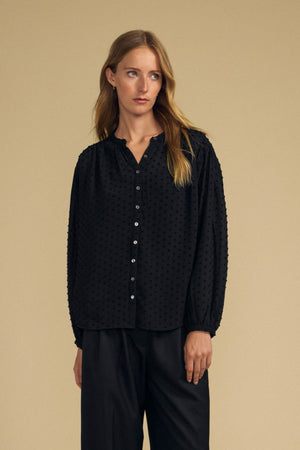 Black ADRIANA TEXTURED CREPE TOP with a button-front, textured crepe fabric, and a dotted pattern.