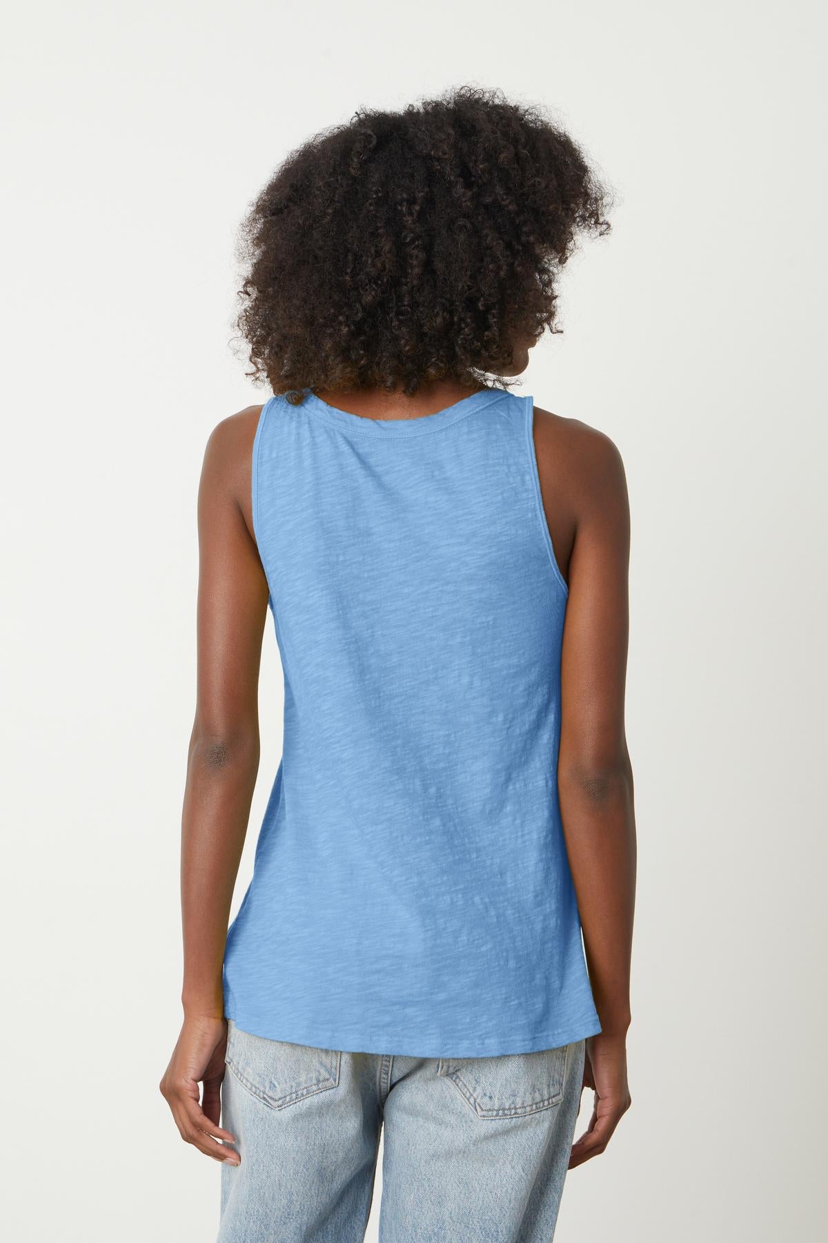 The back view of a woman wearing a Velvet by Graham & Spencer JOY ORIGINAL SLUB SCOOP NECK TANK made of soft cotton.-35201175683265