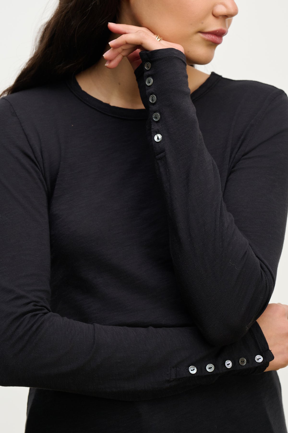 Woman wearing the KELSEY TEE by Velvet by Graham & Spencer, crossing one arm over her body and touching her face.-39815225704641