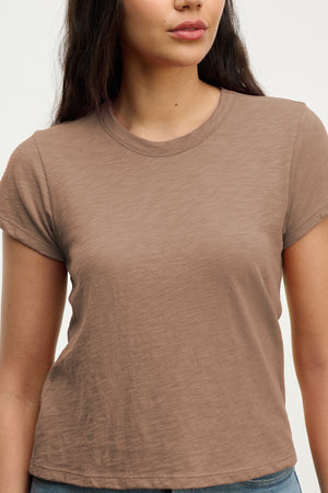 A woman stands against a neutral background wearing the MARIE TEE by Velvet by Graham & Spencer, featuring a relaxed boxy fit.