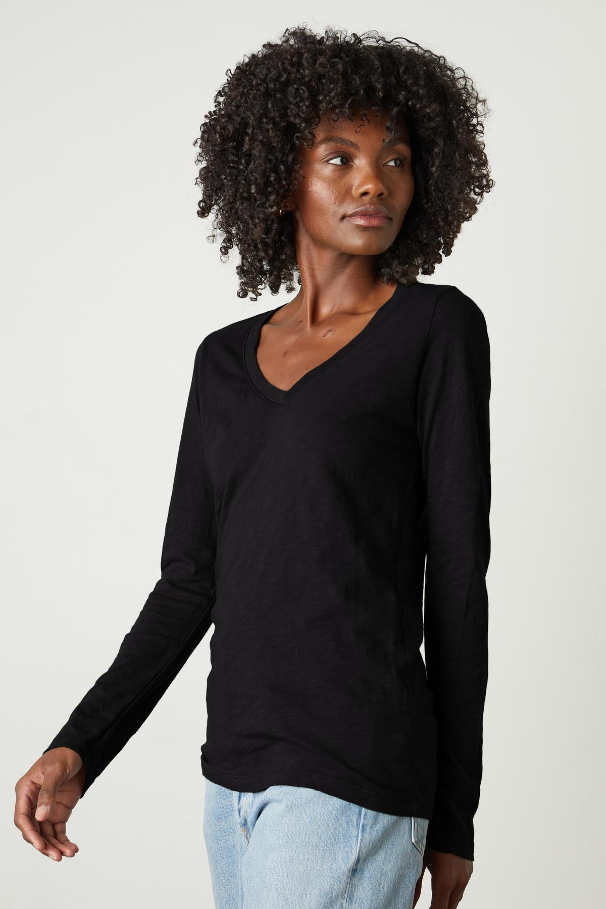   A woman wearing a BLAIRE ORIGINAL SLUB TEE - a Velvet by Graham & Spencer v-neck t-shirt. 