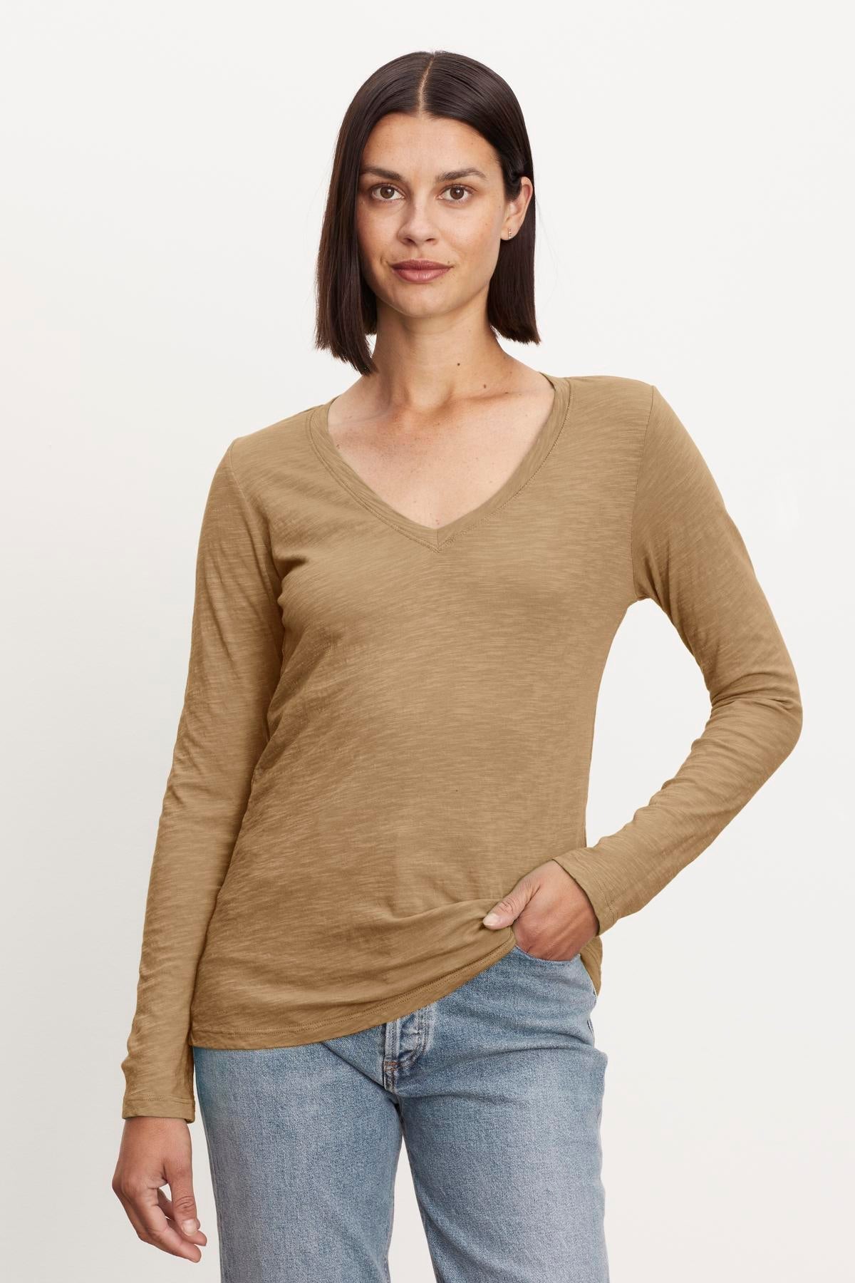   A woman wearing a Velvet by Graham & Spencer BLAIRE ORIGINAL SLUB TEE tan v - neck t - shirt. 