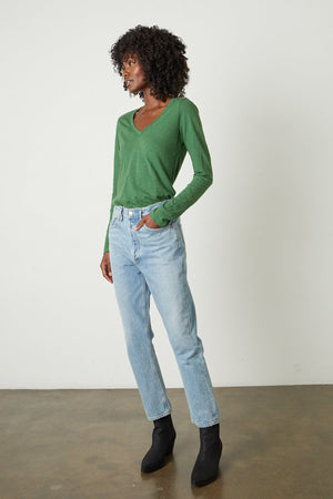 The model is wearing a green Velvet by Graham & Spencer Blaire Original Slub Tee and jeans.