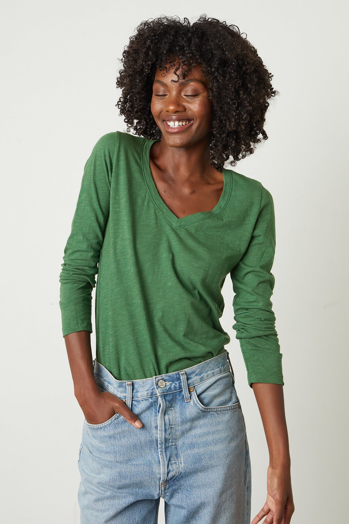   A woman wearing a green Velvet by Graham & Spencer Blaire Original Slub Tee and jeans. 