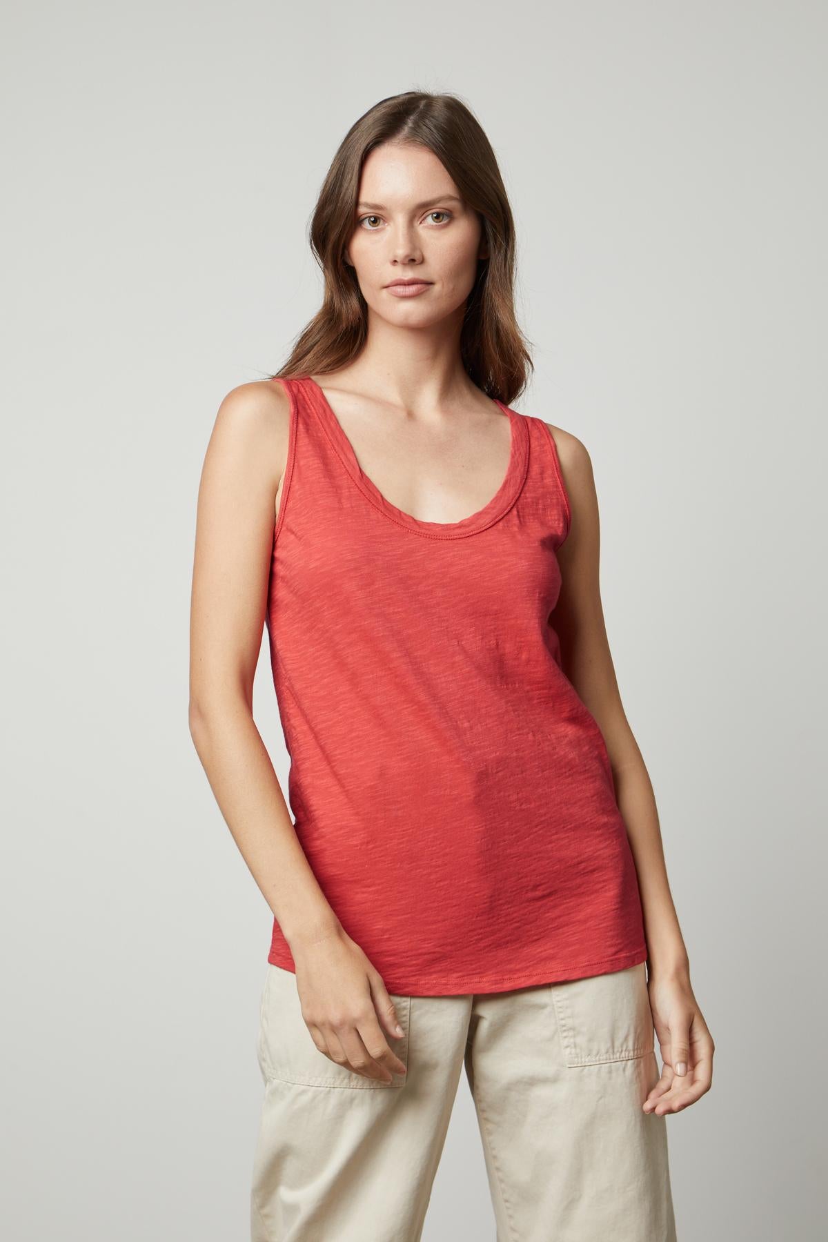   A woman wearing a Velvet by Graham & Spencer JOY ORIGINAL SLUB SCOOP NECK TANK in soft cotton, with flattering arm holes and khaki pants. 