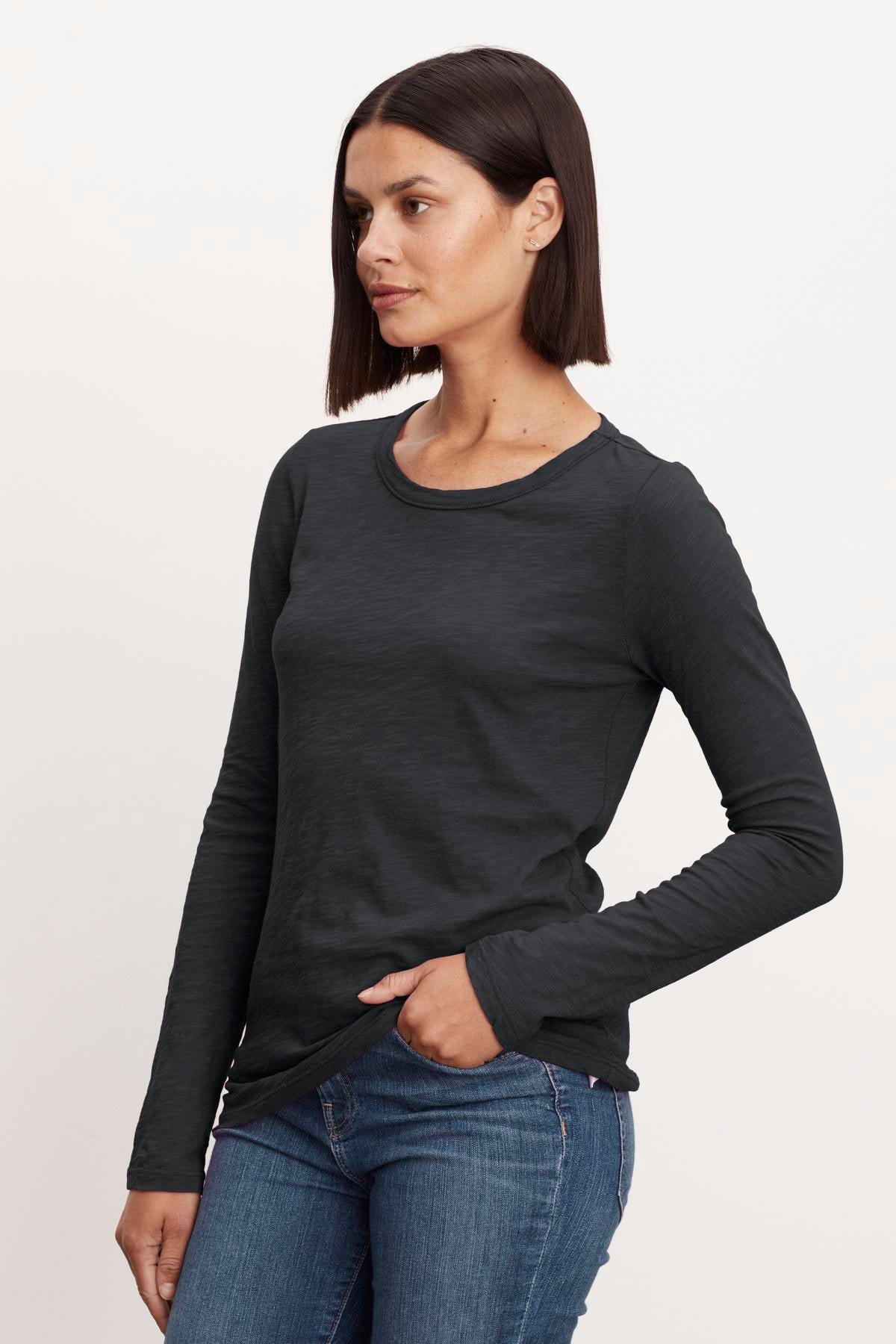   A woman wearing jeans and a Velvet by Graham & Spencer LIZZIE ORIGINAL SLUB LONG SLEEVE TEE. 