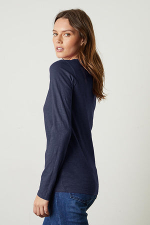 The back view of a woman wearing Velvet by Graham & Spencer LIZZIE ORIGINAL SLUB LONG SLEEVE TEE and cotton jeans.
