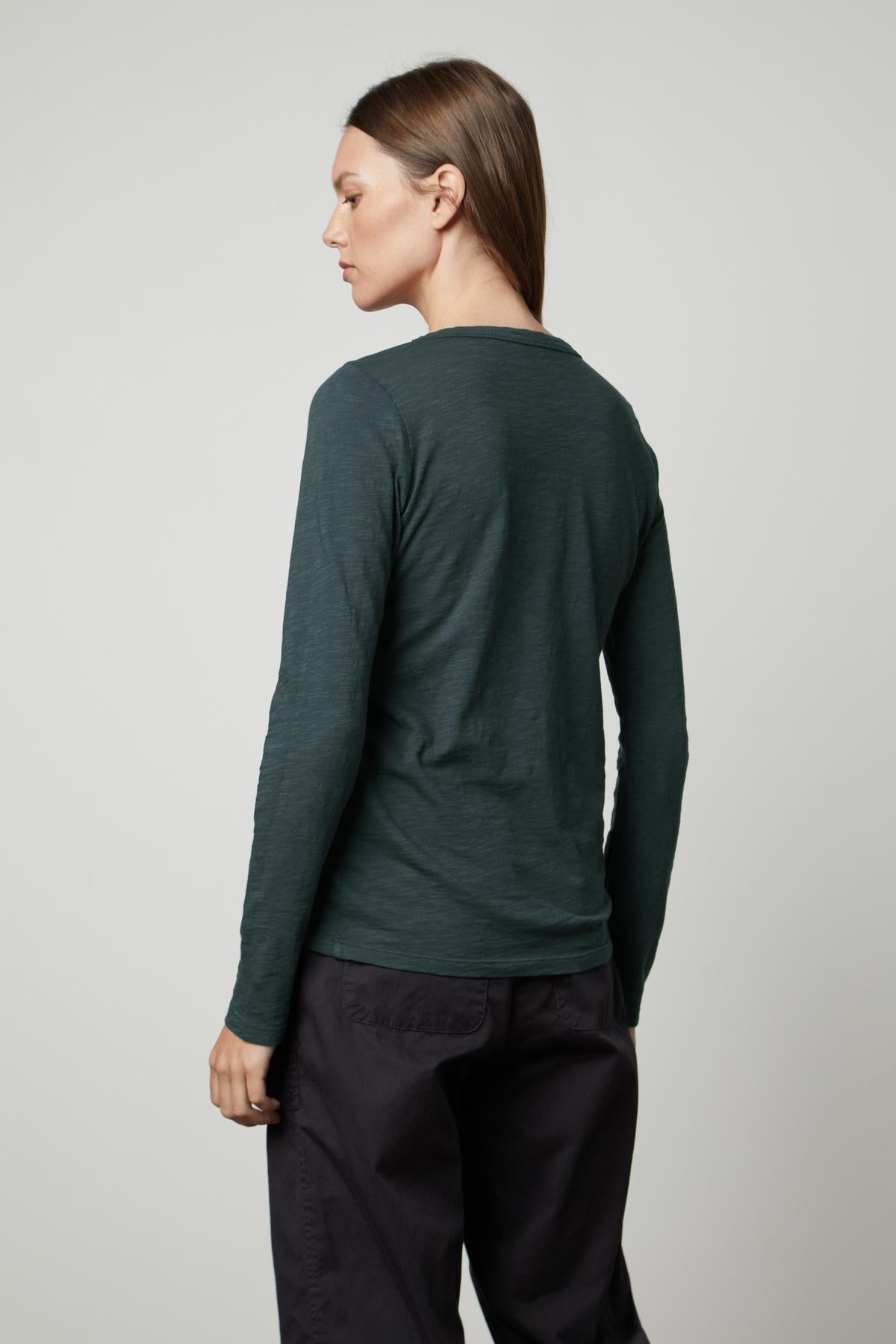   The view of a woman wearing a LIZZIE ORIGINAL SLUB LONG SLEEVE TEE by Velvet by Graham & Spencer from the back. 