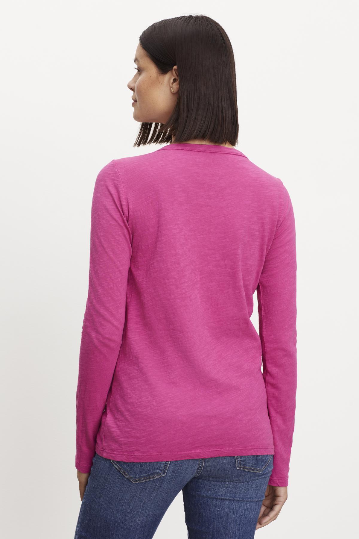 The back view of a woman wearing a Velvet by Graham & Spencer LIZZIE ORIGINAL SLUB LONG SLEEVE TEE.-35701947629761