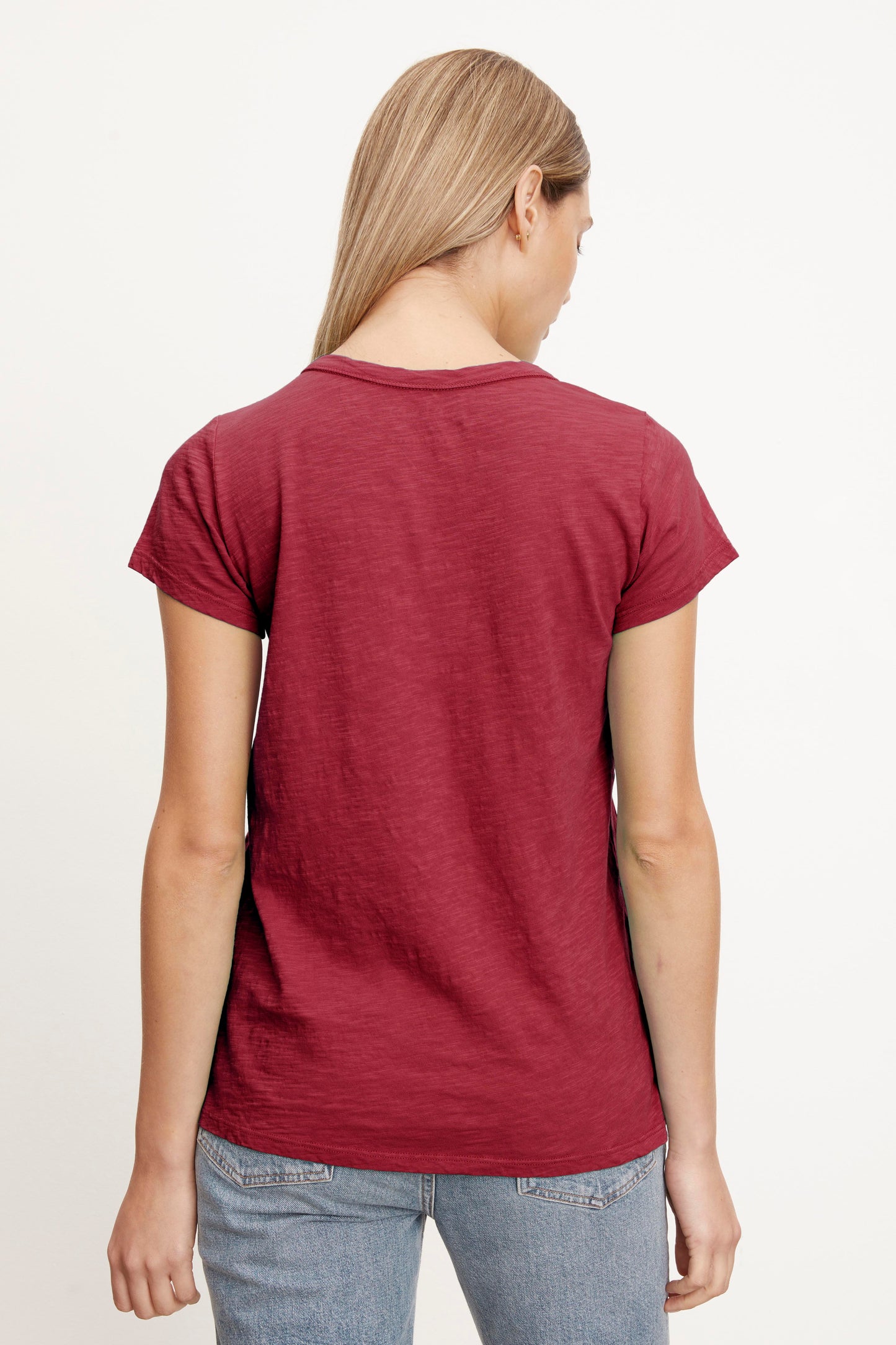 The back view of a woman wearing a Velvet by Graham & Spencer TILLY ORIGINAL SLUB CREW NECK TEE.-26883540353217