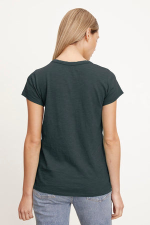 A person with long blonde hair is shown from the back, wearing a dark gray TILLY TEE by Velvet by Graham & Spencer made of soft cotton slub and light blue jeans against a plain white background—a true California classic.