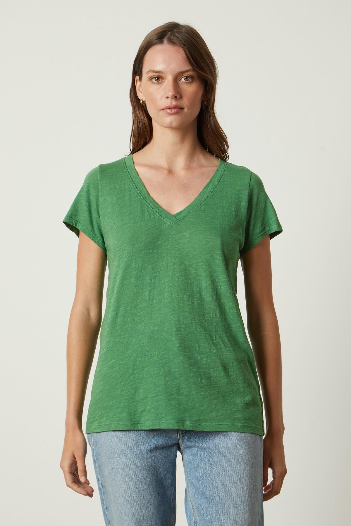 A woman wearing a green Velvet by Graham & Spencer JILIAN ORIGINAL SLUB V-NECK TEE.-26630509789377