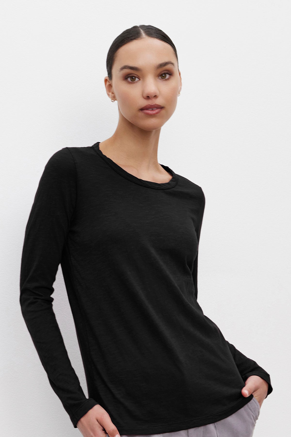 Woman in a LIZZIE TEE by Velvet by Graham & Spencer standing against a plain white background.-37935124578497