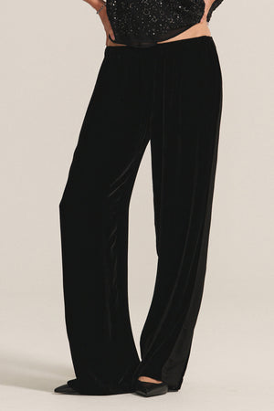 A person wearing the HILMA PANT by Velvet by Graham & Spencer and black pointed-toe shoes stands against a plain background.