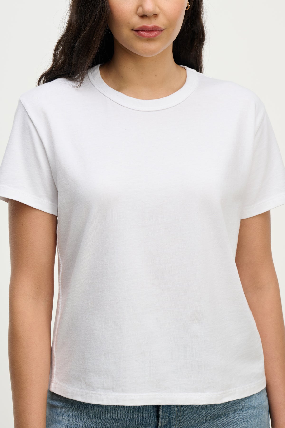 A woman wears the LEIGH TEE by Velvet by Graham & Spencer, a vintage-inspired soft cotton jersey with a relaxed fit, paired with blue jeans and photographed from the waist up against a neutral backdrop.-39742241571009